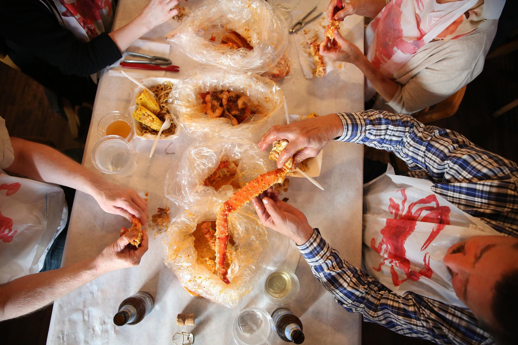 Friends sharing takeout wings and drinks around a table